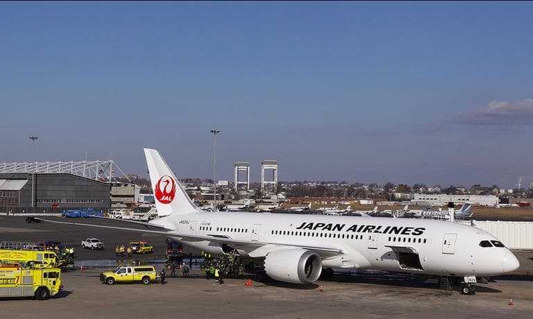 A Japan Airlines Boeing 787 Dreamliner jet aircraft is surrounded by emergency vehicles while parked at a terminal E gate at Logan International Airport in Boston on Monday. A small electrical fire filled the cabin of the JAL aircraft with smoke about 15 minutes after it landed in Boston. (Stephen Savoia/AP)