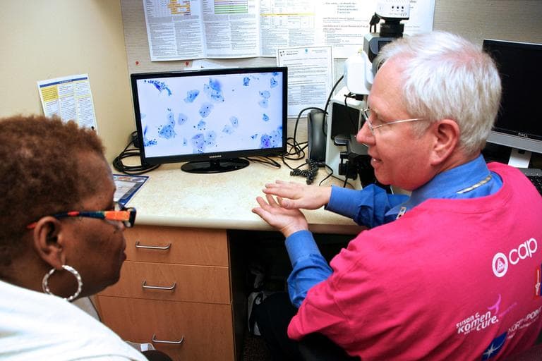 Bradley M. Linzie, MD, FCAP, explains to Precious Marshall of Minneapolis, Minn., her Pap test slide at NorthPoint Health &amp; Wellness Clinic in Minneapolis, Minn. in October. (College of American Pathologists/PRNewsfoto)