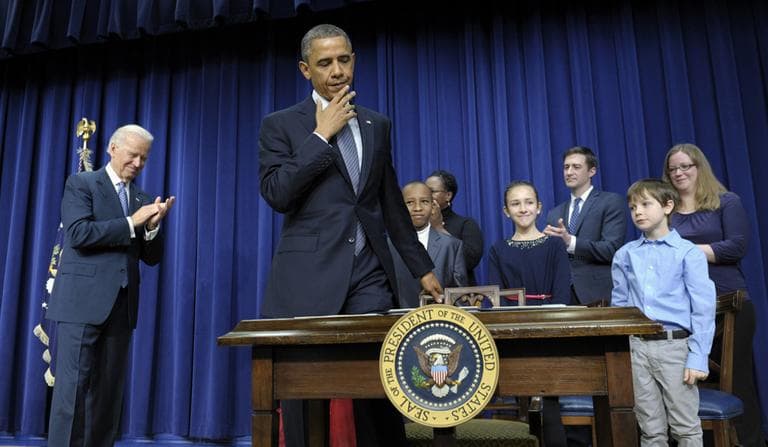 President Barack Obama, accompanied by Vice President Joe Biden and children who wrote the president about gun violence following last month&#039;s shooting at an elementary school in Newtown, Conn., prepares to sit down to sign executive orders on Wednesday. (Susan Walsh/AP)