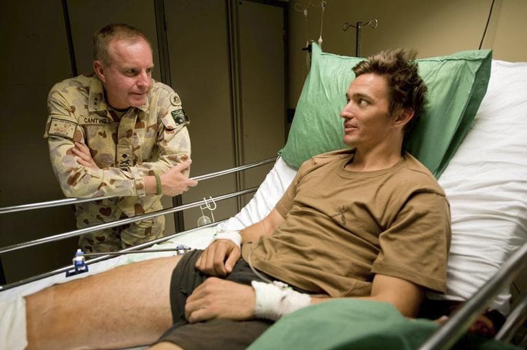 In this undated photo provided by Maj. Gen. John Cantwell, left, the general talks with an unidentified injured man at an undisclosed location in Afghanistan. Maj. Gen. Cantwell, the former commander of Australia’s troops in Afghanistan, spent 20 years secretly suffering from PTSD, which began after he served in the Gulf War and grew worse as he rose through the military’s ranks. (Sgt. Neil Ruskin/AP)