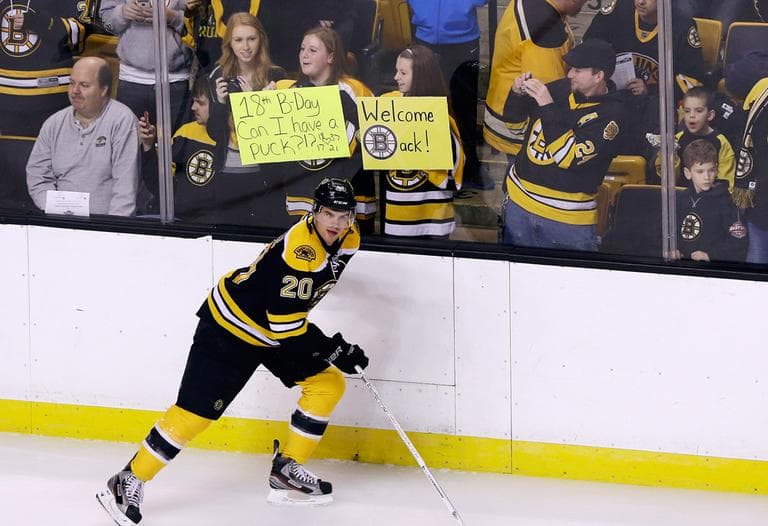 The Bruins&#039; Daniel Paille skates past fans holding signs at Boston&#039;s TD Garden before a scrimmage on Tuesday. (Elise Amendola/AP)