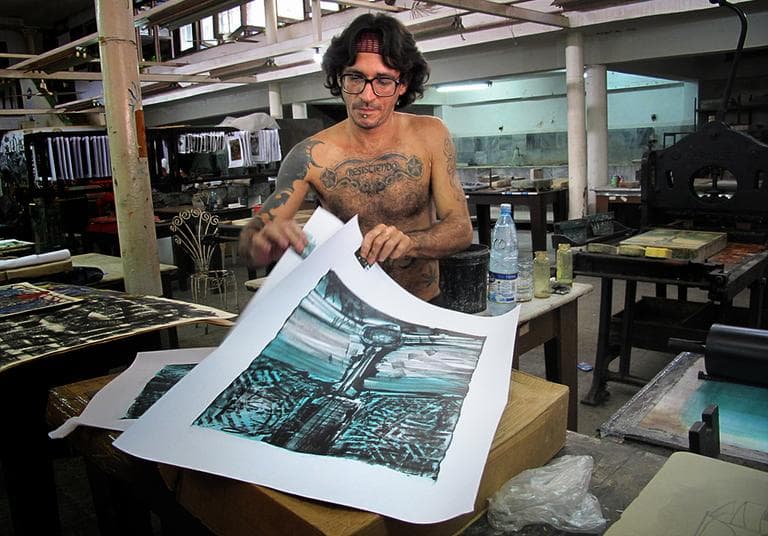 An artist shows his finished work at the Experimental Graphic Arts Studio in Old Havana. Poet Pablo Neruda convinced Che Guevara to open this workshop in the 60s to save the dying art form. Today it’s home to Cuba’s top print makers. (Andrea Shea/WBUR)