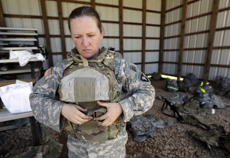 Spc. Sarah Sutphin removes her new body armor, designed to fit  women's physiques, after training on a firing range in September 2012 in Fort Campbell, Ky. (Mark Humphrey/AP)