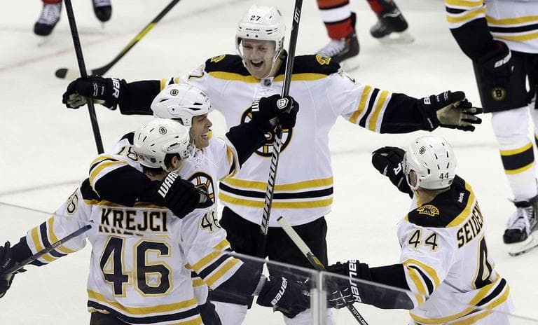 Bruins&#039; David Krejci (46) is congratulated by Nathan Horton, Dennis Seidenberg (44), of Germany, and Dougie Hamilton (27) after Krejci scored the game winning goal against the Carolina Hurricanes. (AP/Gerry Broome)