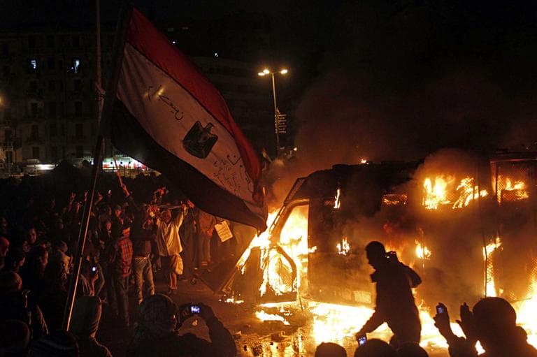 Egyptian protesters use camera phones on Monday to capture a burning state security armored vehicle that demonstrators commandeered during clashes with security forces nearby and brought to Tahrir Square and set it alight, in Cairo, Egypt. (Mostafa El Shemy/AP)