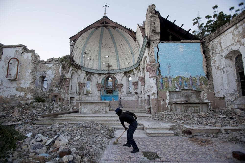 A man sweeps an exposed tiled area of the earthquake-damaged Santa Ana Catholic church, where he now lives, in Port-au-Prince, Haiti, Saturday, Jan. 12, 2013. Haitians recalled Saturday the tens of thousands of people who lost their lives in the devastating earthquake three years ago. Most of the rubble created by the quake has since been carted away but more than 350,000 people still live in displacement camps. (AP Photo/Dieu Nalio Chery)
