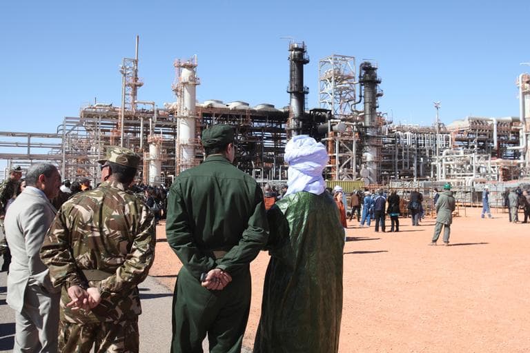 Algerian soldiers and officials stand in front of the gas plant in Ain Amenas, seen in background, during a visit organized by the Algerian authorities for news media on Friday. (AP)