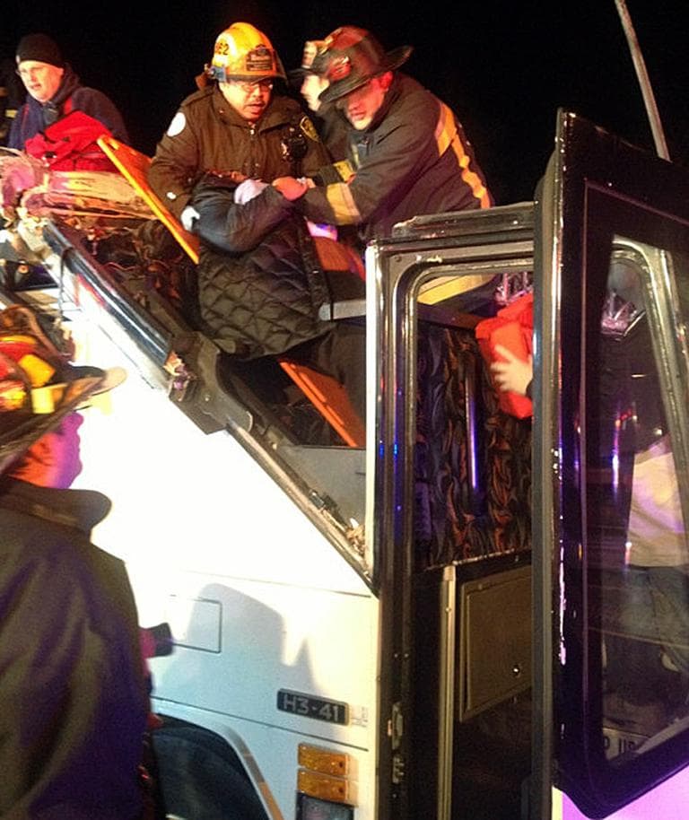 In this photo released by the Boston Fire Department via Twitter, firemen work to remove injured passengers from a bus that hit an bridge as it traveled along Soldiers Field Road in the Allston neighborhood of Boston Saturday night, Feb. 2, 2013. (Boston Fire Department/AP)