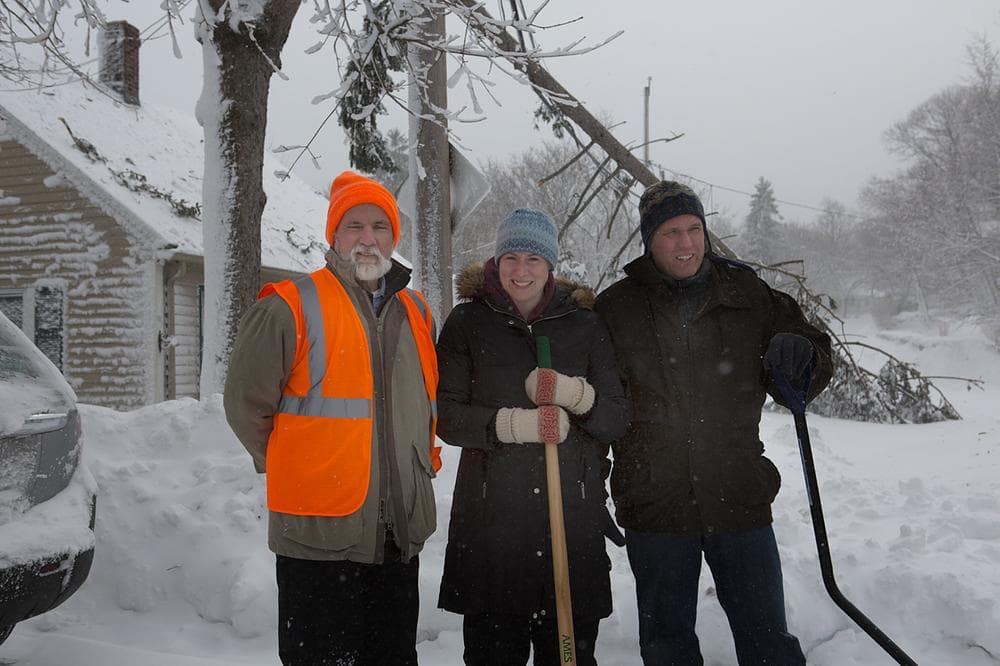 Bob Daly, Natalie and Chris St.George are neighbors on Hull St. on the Hingham and Cohasset border. A tree fell down on a power line, knocking out power on the street. Daly lives in Hingham and the St. Georges live across the street in Cohasset. They were helping each other to shovel snow. Daly says, &quot;It's neighbors helping neighbors.&quot; (Jesse Costa/WBUR)