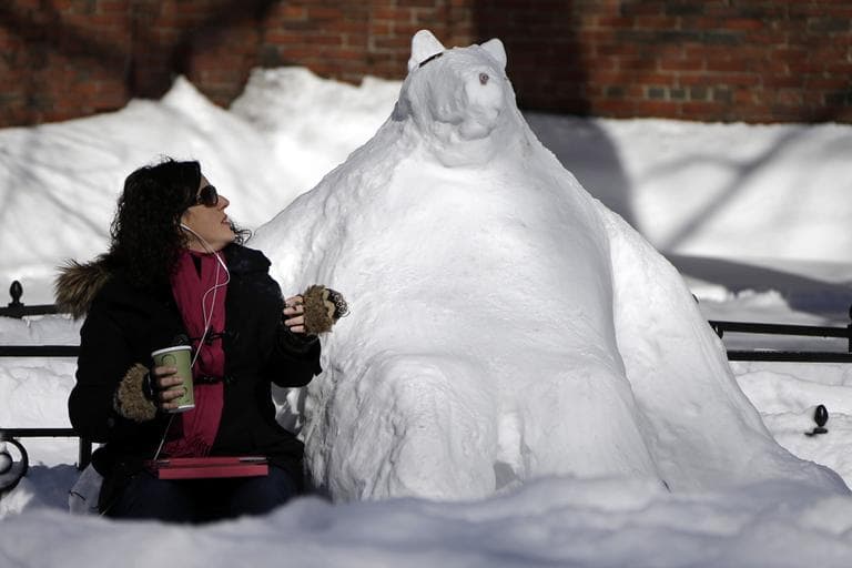 Cheryl Roegner of the North End neighborhood of Boston, sits in the sun and the snow on a bench in Paul Revere Mall next to a snow sculpture she says she did not have a hand in making, Sunday, Feb. 10, 2013 in the North End neighborhood of Boston. (Gene J. Puskar/AP)