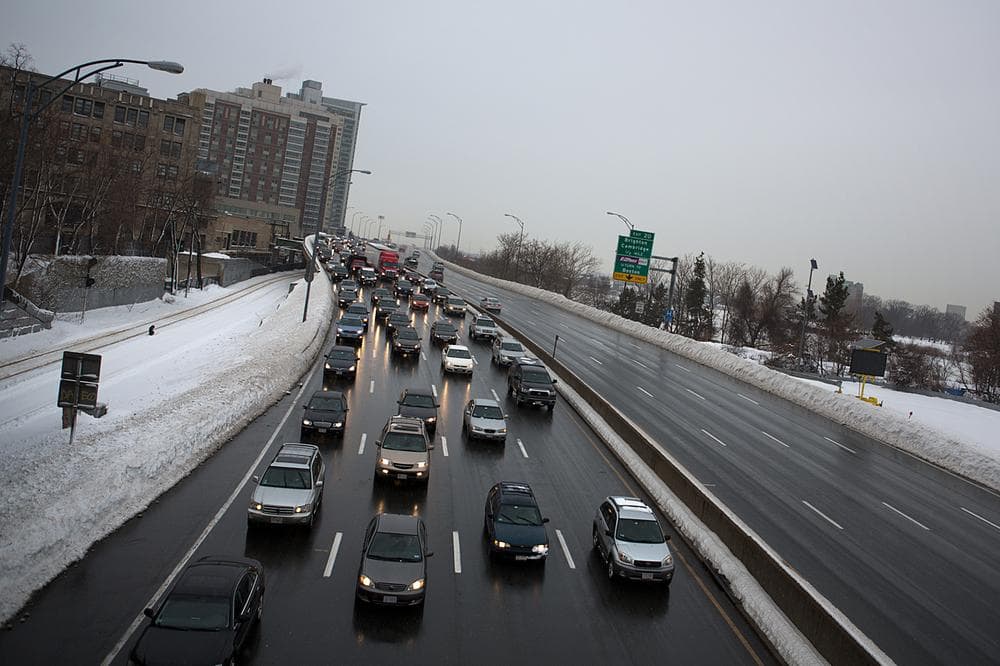 Highways were relatively clear early in the morning commute, but quickly backed up once it started raining. Here, traffic moves slowly east along the Mass Pike Monday morning. (Jesse Costa/WBUR)