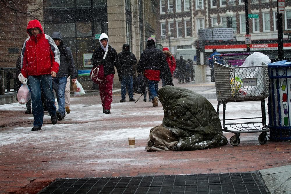 A homeless person panhandles in the snow in Harvard Square, Cambridge, Mass. on Friday, Feb. 8, 2013.(Jesse Costa/WBUR)