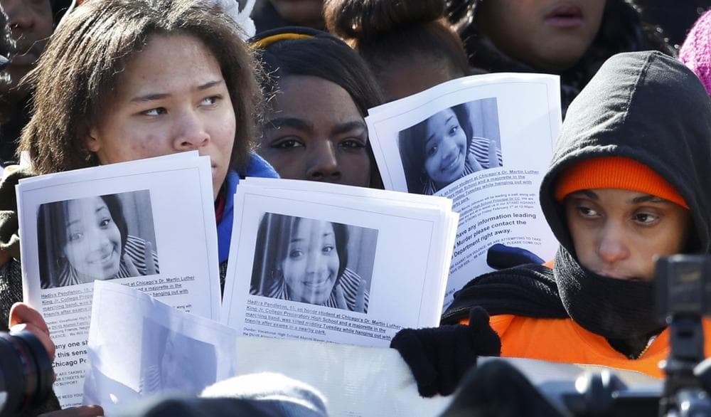Protesters hold up copied photos of Hadiya Pendleton at the scene where she was killed during an anti-gun violence march and rally Friday, Feb. 1, 2013, in Chicago. (Charles Rex Arbogast/AP)