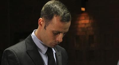 Olympic athlete Oscar Pistorius stands inside the court as a police officer looks on during his bail hearing at the magistrate court in Pretoria, South Africa, Wednesday, Feb. 20, 2013. (Themba Hadebe/AP)