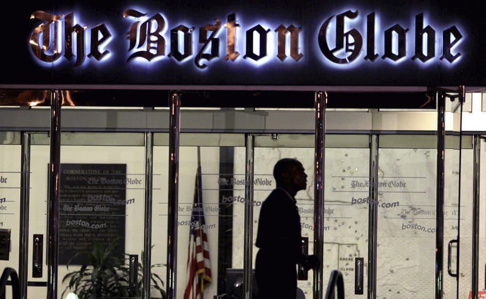 A security guard walks past the entrance of  the Boston Globe building in Dorchester on July 20, 2009. (Charles Krupa/AP)
