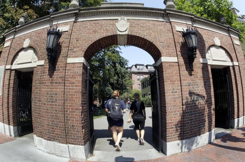 Pedestrians walk through a gate on the campus of Harvard University in Cambridge, Mass. Thursday, Aug. 30, 2012. Dozens of Harvard University students are being investigated for cheating after school officials discovered evidence they may have wrongly shared answers or plagiarized on a final exam. Harvard officials on Thursday didn't release the class subject, the students' names, or specifically how many are being investigated. (AP Photo/Elise Amendola)