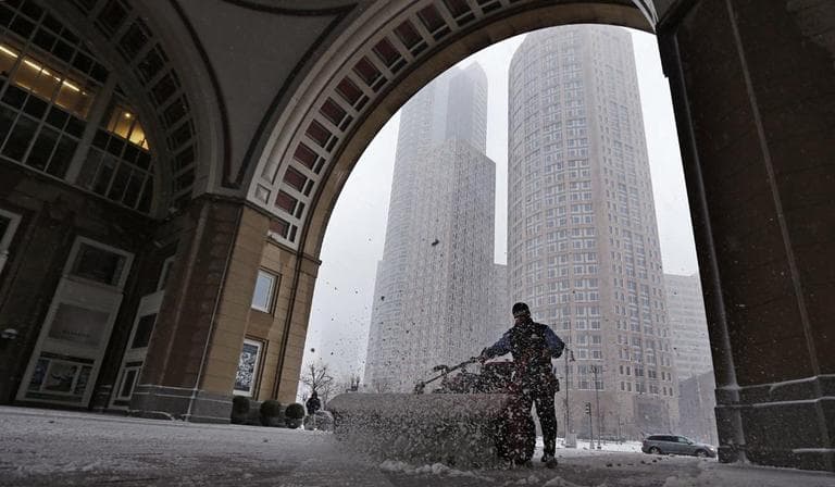 A worker power-sweeps snow from under the arch at Rowe's Wharf as a winter snowstorm intensifies in Boston Feb. 8. Gov. Deval Patrick declared a state of emergency Friday and banned travel on roads as of 4 p.m. as a blizzard that could bring nearly 3 feet of snow to the region began to intensify. (Charles Krupa/AP)