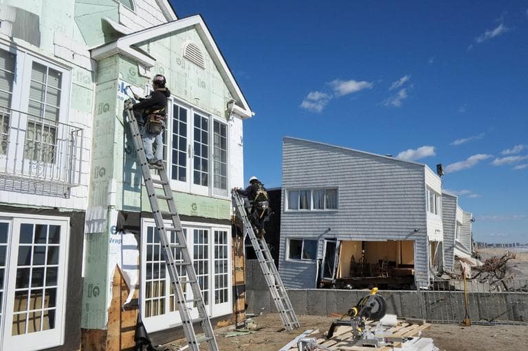 Carpenters install new siding on a storm-damaged beachfront house in the Far Rockaways, Thursday, Jan. 31, 2013 in the Queens borough of New York. (AP)