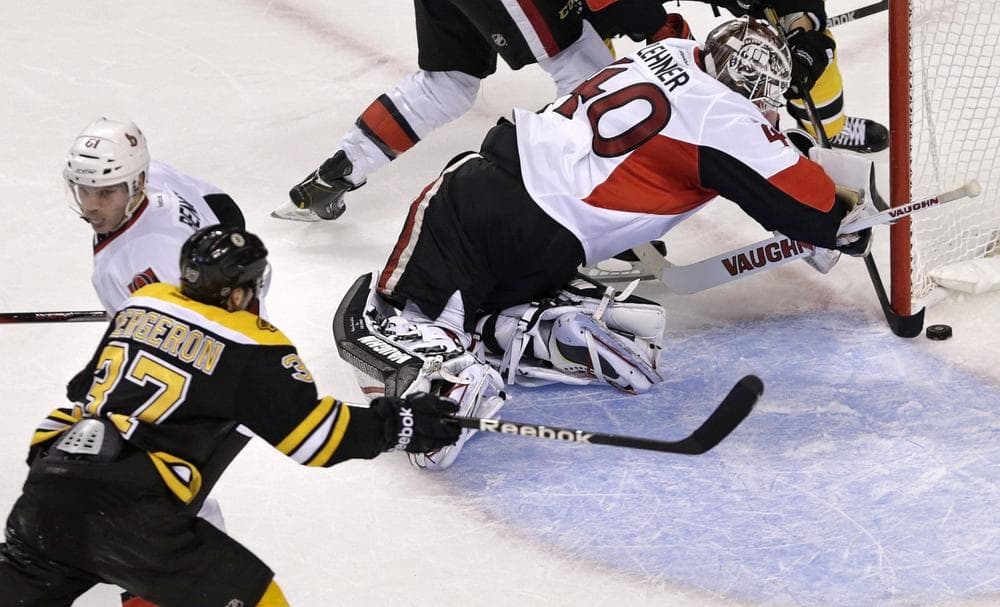 Ottawa Senators goalie Robin Lehner (40) tries to get his stick around as the puck crosses the goal line into the net on a goal by Boston Bruins center Patrice Bergeron. (Charles Krupa/AP)