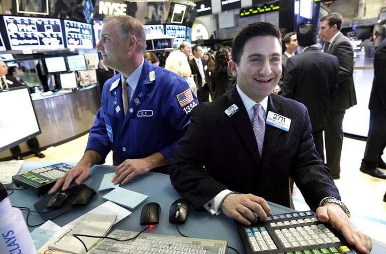Specialist Christian Sanfillippo, right, smiles as he works at his post on the floor of the New York Stock Exchange on Tuesday, March 5, 2013. (Richard Drew/AP)