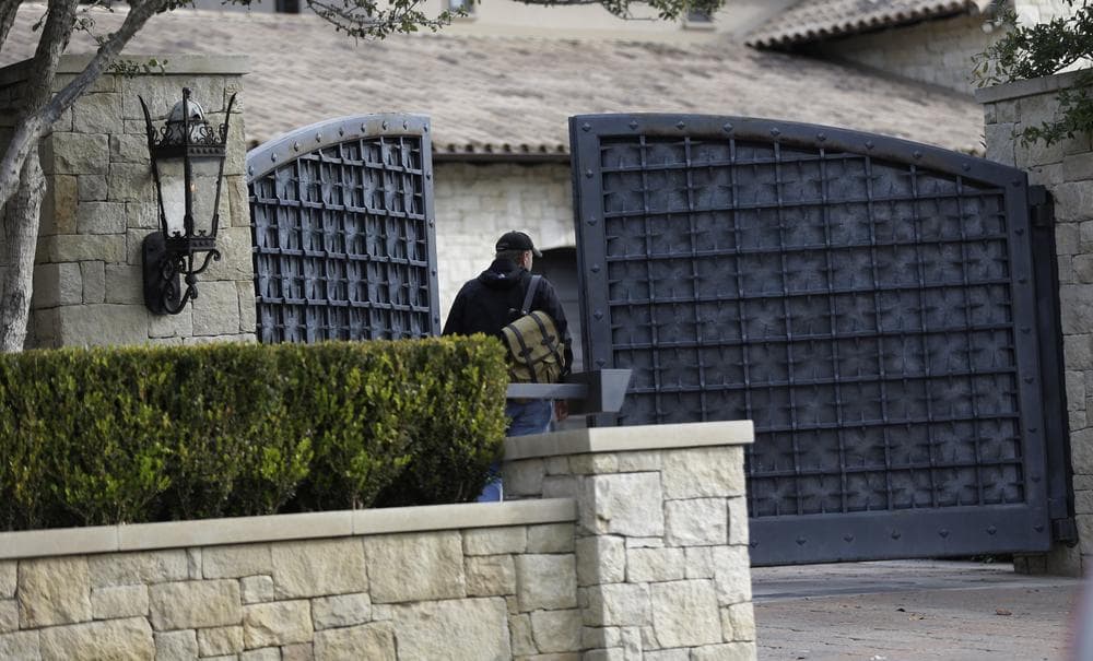 An unidentified man (not Michael McCann) enters a gate at the home of cyclist Lance Armstrong.  (AP/Eric Gay)