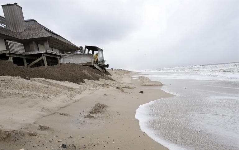 As the tides starts to come in, Bill Heckman uses a bulldozer to push sand while rebuilding a breached dune In Mantoloking, N.J., Thursday, March 7, 2013. In a storm overnight Thursday, pounding surf broke through a temporary dune during the early-morning high tide causing more damage to some homes already damaged by Superstorm Sandy and flooding some roads.  (Mel Evans/AP)