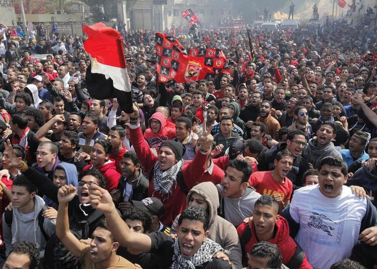 Egyptian soccer fans of Al-Ahly club wave national and Al-Ahly flags as they celebrate in front of their club headquarters in Cairo, Egypt, Saturday, March 9, 2013. (Amr Nabil/AP)