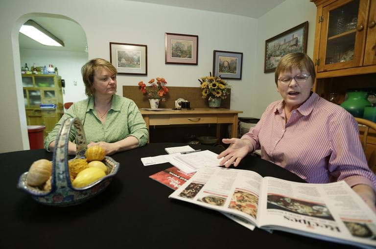Kimberly Bliss, left, and her wife Kim Ridgway, right, look at recipes for marijuana &quot;edibles&quot; as they sit at their dining room table in February 2013. (Ted S. Warren/AP)