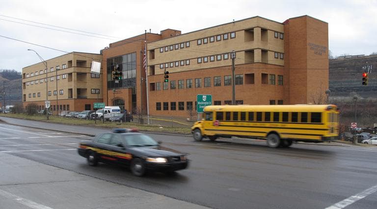 A sheriff's cruiser and a school bus cross paths in front of the Jefferson County Justice Center, Feb. 27, 2013 in Steubenville, Ohio. (Andrew Welsh-Huggins/AP)