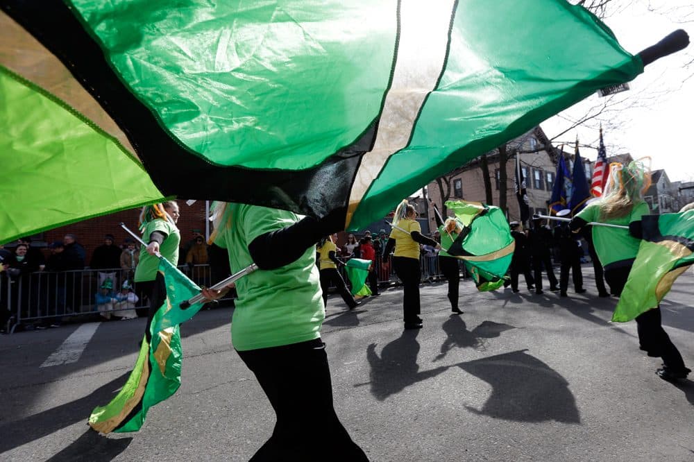 Women from the Sanford High School color guard, of Sanford, Me., twirl green flags while marching in a St. Patrick's Day Parade, in South Boston, Sunday, March 17, 2013. (Steven Senne/AP)