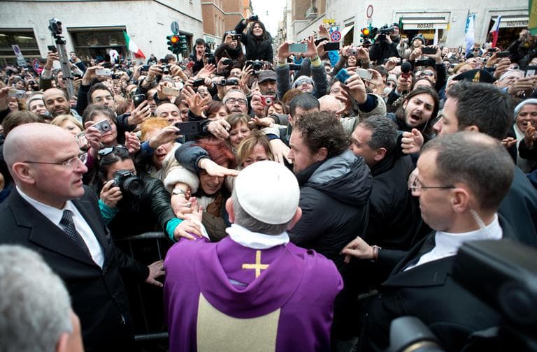 In this photo provided by the Vatican paper L'Osservatore Romano, Pope Francis greets faithful after making an impromptu appearance  from a side gate of the Vatican, Sunday, March 17, 2013. (L'Osservatore Romano/AP)