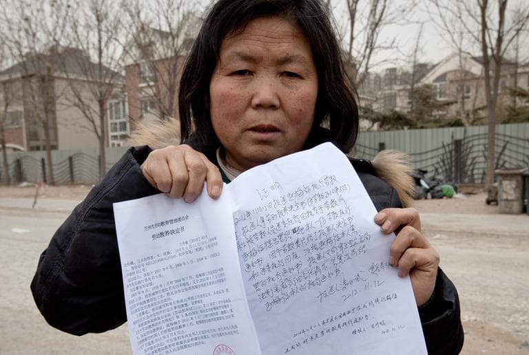 Zhao Meifu, a farmer from Gansu province, shows the papers of her labor camp detention in Beijing, March 9, 2013. Zhao had been seeking redress for decades over a land grab by village officials. Tired of her complaints, police saw the labor camp as a quick way to get rid of her. She was locked up in a long hated and often abused penal system known as labor re-education. (Andy Wong/AP)