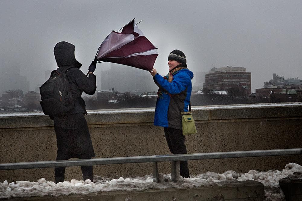 A woman&#039;s umbrella is turned inside-out Tuesday morning on BU Bridge. (Jesse Costa/WBUR)