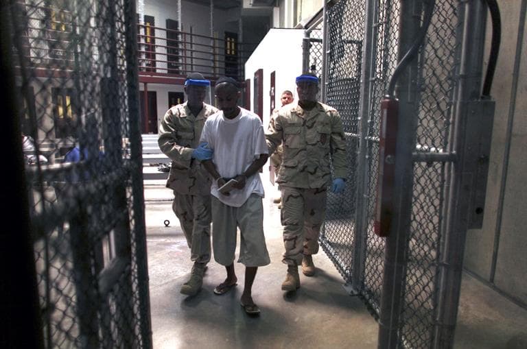 A Guantanamo detainee carries a workbook as he is escorted by guards after attending a class in &quot;Life Skills,&quot; inside Camp 6 high-security detention facility at Guantanamo Bay U.S. Naval Base, Cuba, March 30, 2010. Cuba. (Brennan Linsley/AP)