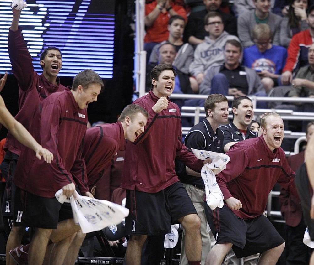 Members of the Harvard men's basketball team celebrate after the Crimson beat New Mexico Thursday night, winning the school's first NCAA tournament game.  (George Frey/AP)