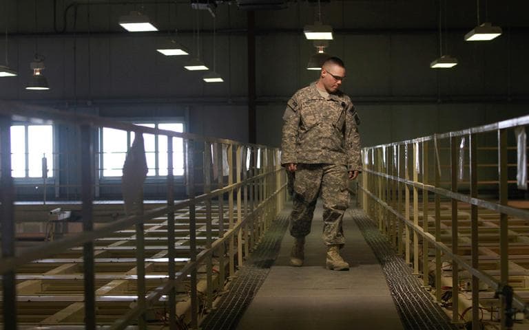 In this March 23, 2011, file photo a U.S. military guard watches over detainee cells inside the Parwan detention facility near Bagram Air Field in Afghanistan.