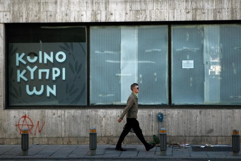 A man passes an empty closed branch of Bank of Cyprus in central capital Nicosia, Cyprus, Sunday, March 24, 2013. (Petros Karadjias/AP)