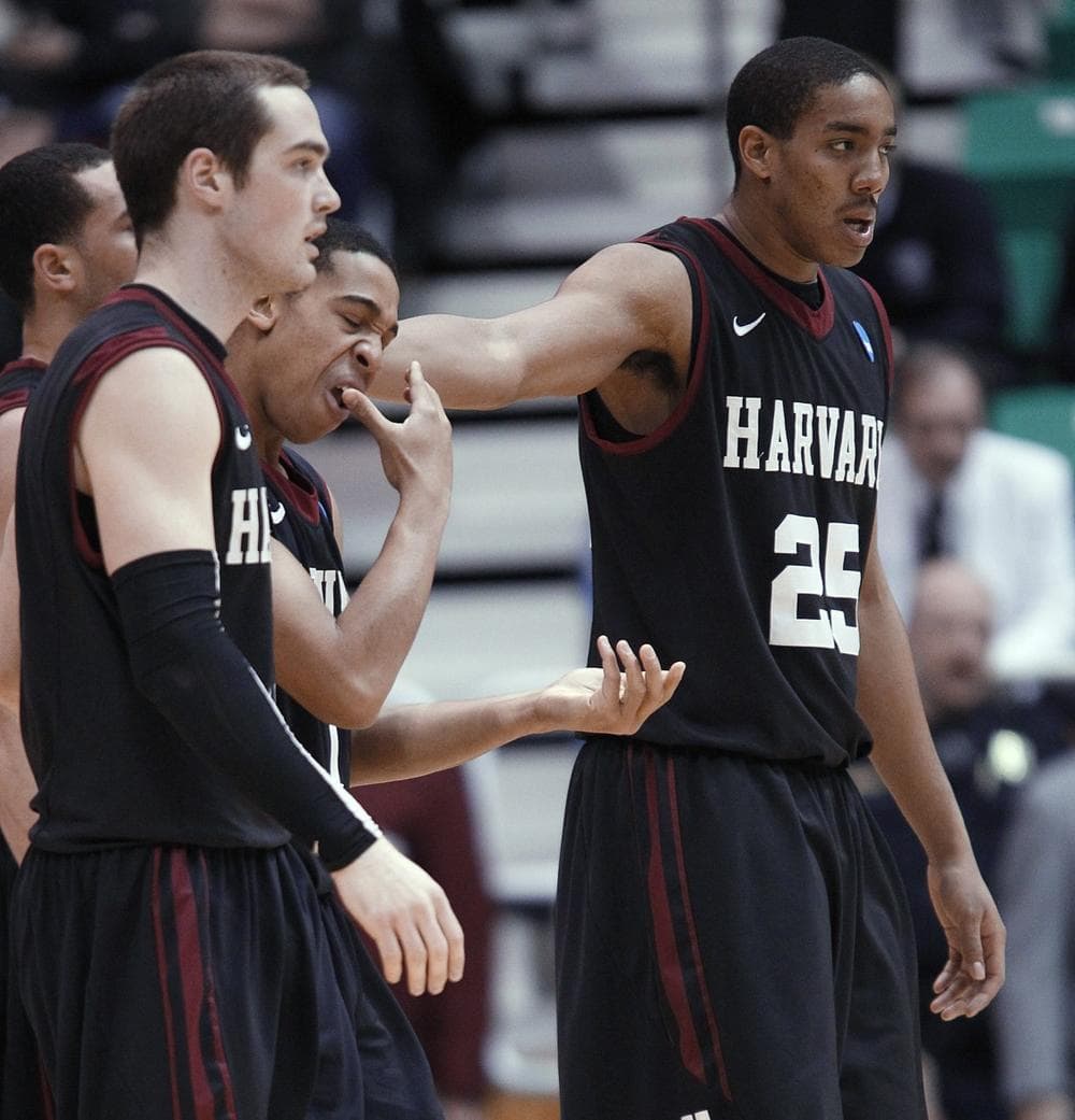 Harvard's Christian Webster, right, and Larent Rivard help Siyani Chambers, who had part of a tooth knocked out, off the court in the second half against Arizona. (AP Photo/George Frey)