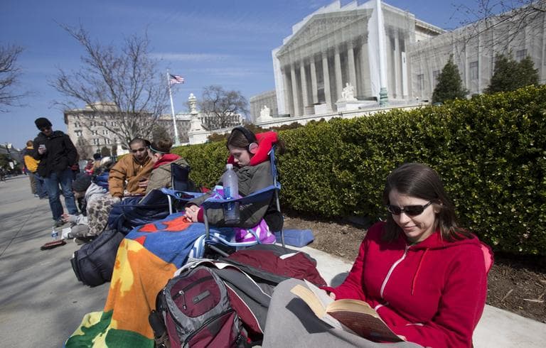 In this photo taken Saturday, March 23, 2013, Jessica Skrebes of Washington reads while waiting in line with others outside of the U.S. Supreme Court in Washington in anticipation of Tuesday's Supreme Court hearing on California's Proposition 8 ban on same-sex marriage, and Wednesday's Supreme Court hearing on the federal Defense of Marriage Act, which defines marriage as the union of a man and a woman. (Jacquelyn Martin/AP)