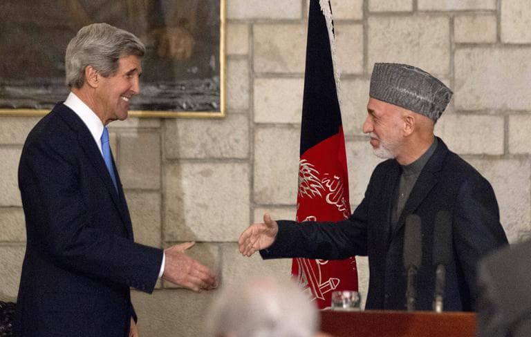 Secretary of State John Kerry reaches to shakes hands with Afghan President Hamid Karzai at the end of their joint news conference at the Presidential Palace in Kabul, Monday, March 25, 2013. (Jason Reed/AP Pool)