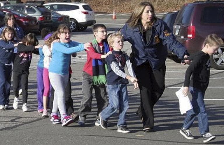 In this photo provided by the Newtown Bee, Connecticut State Police lead children from the Sandy Hook Elementary School in Newtown, Conn., following a reported shooting there Friday, Dec. 14, 2012.  (Newtown Bee, Shannon Hicks/AP)