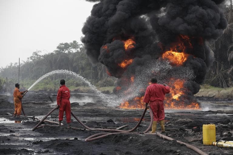 Fire fighters try to contain flames  from a burning oil pipeline in Ijeododo outskirt of  Lagos, Nigeria  Thursday, Dec. 20, 2012. The oil pipeline belonging to Nigeria National Petroleum Cooperation exploded near Nigeria's largest city as thieves tried to siphon oil from it  Monday. (AP Photo/Sunday Alamba)