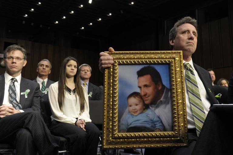 Neil Heslin, the father of a six-year-old boy who was slain in the Sandy Hook massacre in Newtown, Conn., on Dec. 14, holds a picture of himself with his son Jesse and wipes his eye while testifying on Capitol Hill in Washington, Wednesday, Feb. 27, 2013, before the Senate Judiciary Committee on the Assault Weapons Ban of 2013. (AP)