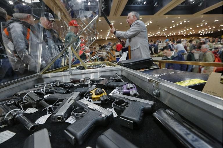 Handguns on display at the table of David Petronis of Mechanicville, N.Y., right, who owns a gun store there, during the heavily attended annual New York State Arms Collectors Association Albany Gun Show at the Empire State Plaza Convention Center, on Saturday, Jan. 26, 2013, in Albany, N.Y. (AP)