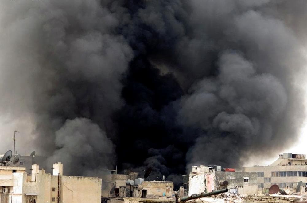 In this Tuesday March 19, 2013, citizen journalism image provided by Aleppo Media Center AMC which has been authenticated based on its contents and other AP reporting, black smoke rise from buildings due to government forces shelling, in Aleppo, Syria. (AP)