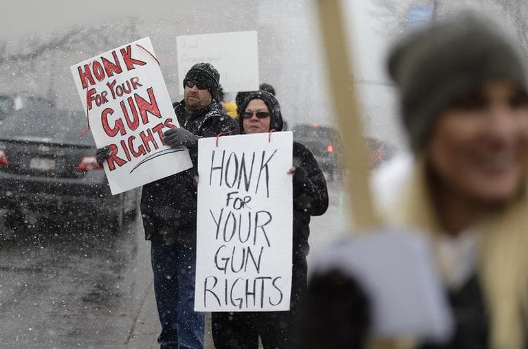 Opponents of proposed gun control bills being considered by the Colorado Legislature holds signs to those passing in cars in front of the State Capitol, in Denver, Monday March 4, 2013. (AP/Brennan Linsley)
