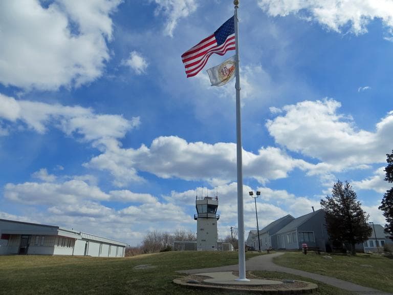 Roughly 100 feet behind the flagpole is the air traffic control tower of Norwood Memorial Airport. (Bruce Gellerman/WBUR)