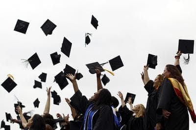 Graduates toss their hats in the air. (Matt Rourke/AP)