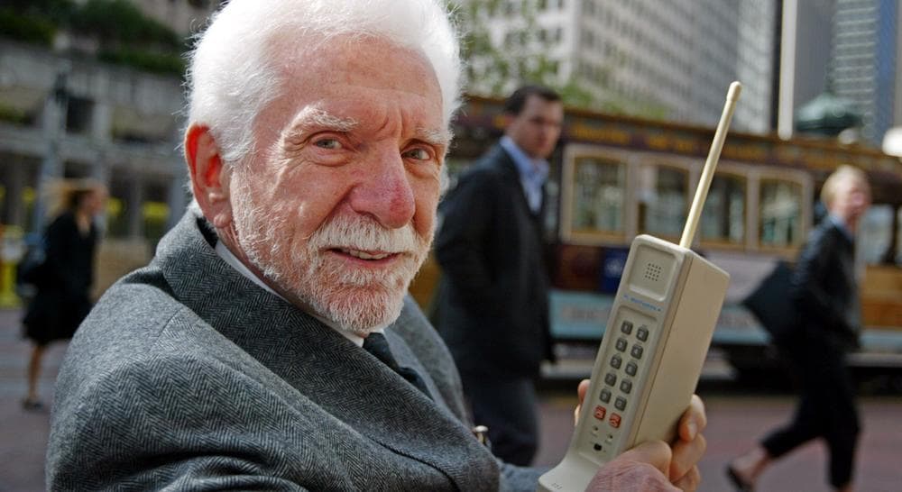 Martin Cooper, chairman and CEO of ArrayComm, holds a Motorola DynaTAC, a 1973 prototype of the first handheld cellular telephone on Market Street in San Francisco, Wednesday April 2, 2003.(Eric Risberg/AP) 