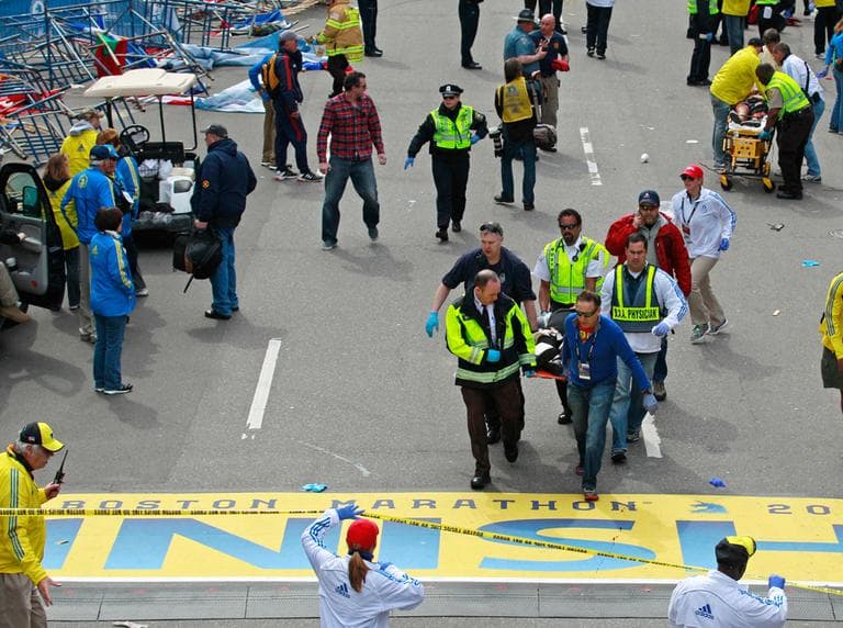 Medical workers wheel the injured across the finish line during the 2013 Boston Marathon following an explosion in Boston, Monday, April 15, 2013. Two explosions shattered the euphoria of the Boston Marathon finish line on Monday, sending authorities out on the course to carry off the injured while the stragglers were rerouted away from the smoking site of the blasts. (Charles Krupa/AP)